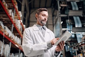 Portrait,Of,Male,Factory,Worker,In,White,Robe,,Using,Tablet